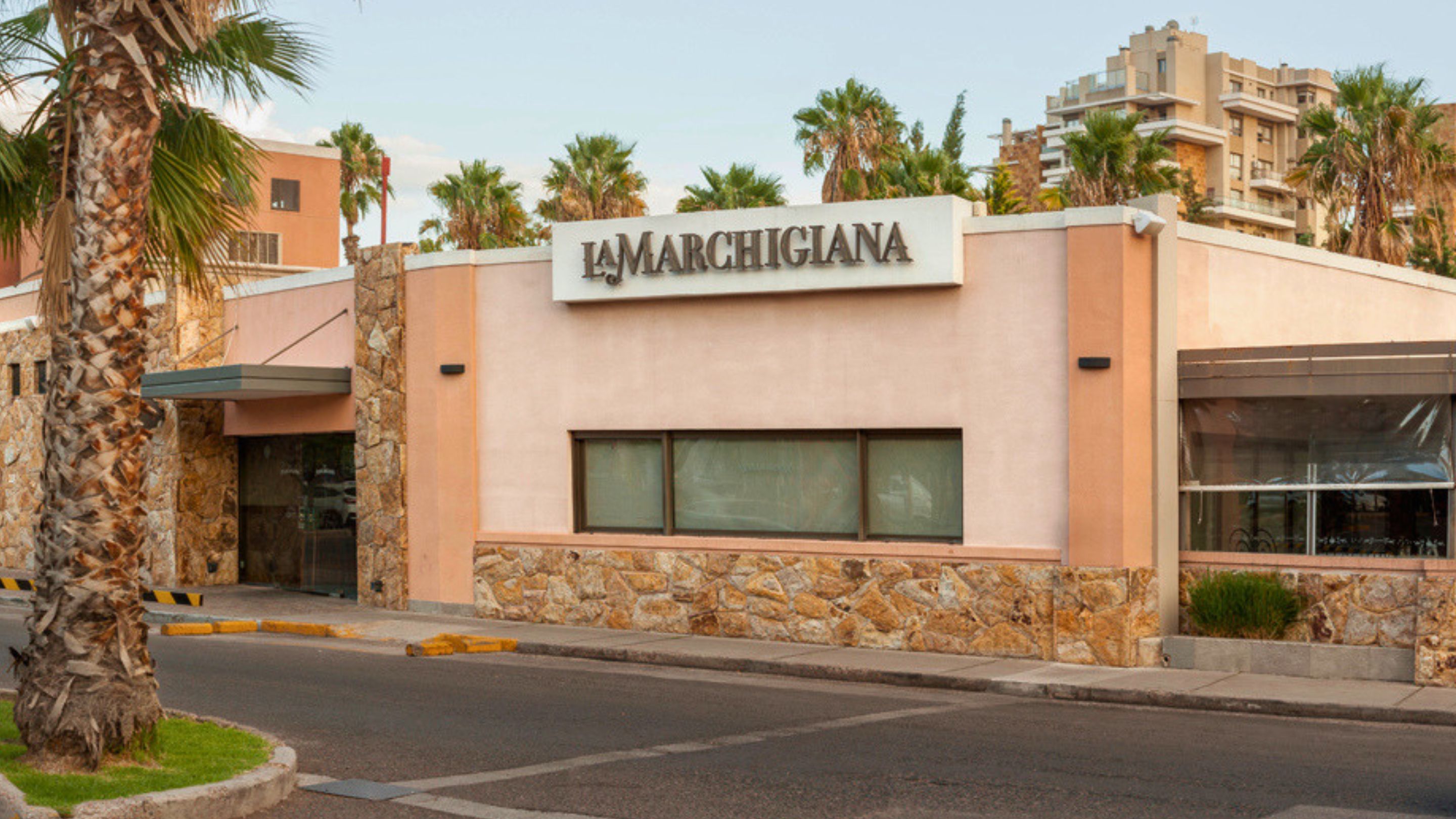 Fachada de La Marchigiana Palmares, rodeada de palmeras